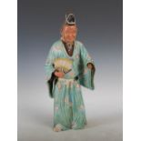 A Japanese pottery figure of an attendant, Meiji Period, modelled standing holding a fan,