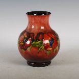 A Moorcroft flambe glazed vase, decorated with anemone and foliage, impressed marks and green