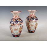 A pair of Japanese Imari vases, late 19th/ early 20th century, decorated with figures in a garden of