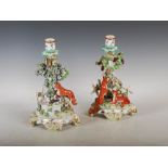 A pair of late 19th century Continental Chelsea style porcelain candlesticks, one modelled with