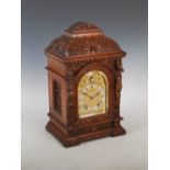 A late 19th century oak mantle clock, the brass dial with silvered chapter ring bearing Arabic and