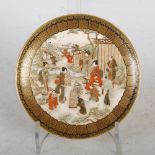 A Japanese Satsuma pottery dish, Meiji Period, decorated with family groups in a river landscape,