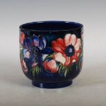 A Moorcroft blue ground pottery jardiniere, decorated with anemone and foliage, impressed marks