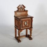A late 19th century Continental walnut and ivory inlaid side cabinet, the upright back with broken