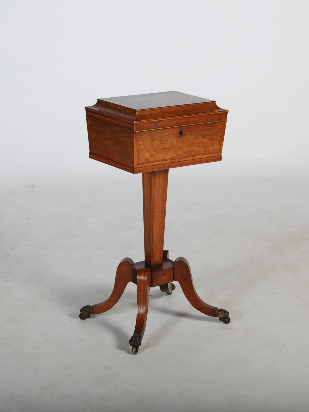 A 19th century rosewood and satinwood banded tea poy, the sarcophagus shaped top with a hinged cover