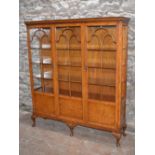 An early 20th century walnut display cabinet by WARING & GILLOW, the rectangular top with a