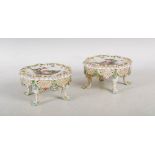 A pair of late 19th century Dresden porcelain vase/ jar stands, the shaped circular tops decorated