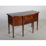 A George III mahogany and boxwood lined breakfront sideboard, the shaped rectangular top above a