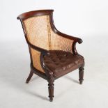 A William IV mahogany Bergere library chair, with scroll carved top rail and foliate carved arms,