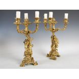 A pair of 19th century French Rococo style ormolu three light candelabra, the foliate cast nozzles