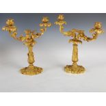 A pair of 19th century French Rococo style ormolu candelabra, the urn shaped nozzles and foliate