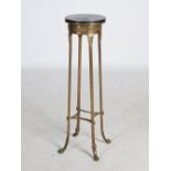 An early 20th century gilt metal and marble topped jardiniere stand, the black marble top above a