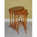 A nest of three early 20th century painted satinwood occasional tables, the largest decorated with