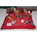 Large collection of costume brooches on cushion