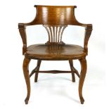 An Edwardian oak office chair, scrolling back rest with pierced splat over solid seat, raised arm