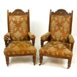 A pair of Victorian oak framed ladies and gentleman's easy chairs, carved crest above the padded