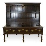 A George lll and later oak dresser, the plate rack with tongue and groove panelling and series of