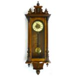 A Vienna Style wall clock, the gallery applied with mask decoration flanked by turned finials,