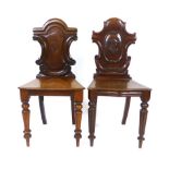 Two Victorian mahogany hall chairs, with carved scrolling back over solid seats, turned front