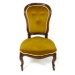 A Victorian walnut spoon back nursing chair, buttoned back rest, stuffed over serpentine seat and