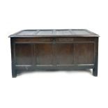 An oak coffer, late 17th/early 18th century, four panelled cover enclosing a vacant interior,