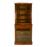 A Victorian walnut bookcase, circa 1870, in two sections with glazed doors enclosing adjustable