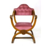 A beechwood X frame chair, early 20th century, buttoned camel back above an upholstered seat and