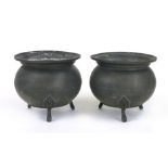 A pair of Arts and Crafts style pewter cauldrons, raised on three feet with foliate designs,  h.