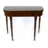 A mahogany foldout tea table, first half of 19th century, cross banded and line inlaid surface