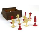 A turned ivory chess set, red stained and natural, the royal pieces with floral carving, height of