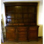 A George lll and later oak breakfront dresser, later 18th century, the later two shelf plate rack