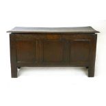 An oak coffer, late 17th/18th century, with a hinged lid above a lunette carved top rail and