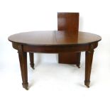 A mahogany oval extending dining table, plain frieze and carved Neo Classical stylised flower heads,