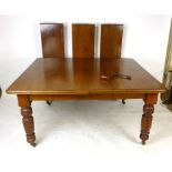 A mahogany wind out extending dining table, circa. 1900, with rounded rectangular top, turned legs