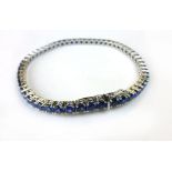 An 18ct white gold tennis-type bracelet set with blue coloured stones CONDITION REPORT: Stones