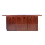 A Skovby stained cherrywood sideboard, the rectangular top overhanging the three doors, on a