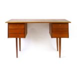 A 1960/70's teak desk with two three-drawer pedestals suspended below on circular tapering legs,