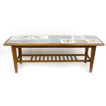 A 1970's tile topped and teak coffee table of rectangular cushioned form with a second tier, l.