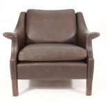 A 1970's brown leather lounge armchair with outswept arms on mahogany straight legs CONDITION