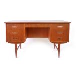 A 1960's teak and crossbanded desk with an arrangement of nine drawers on square tapering legs, l.