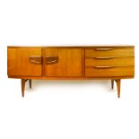 A 1960's teak bow-fronted sideboard, the two doors besides three drawers, on square tapering legs,