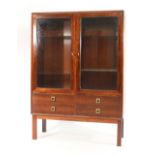 A 1960's rosewood twin door glazed display cabinet with four drawers below on square straight