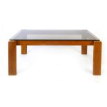 A 1970's glass and teak rectangular coffee table of cushioned form, l. 106 cm CONDITION REPORT: No