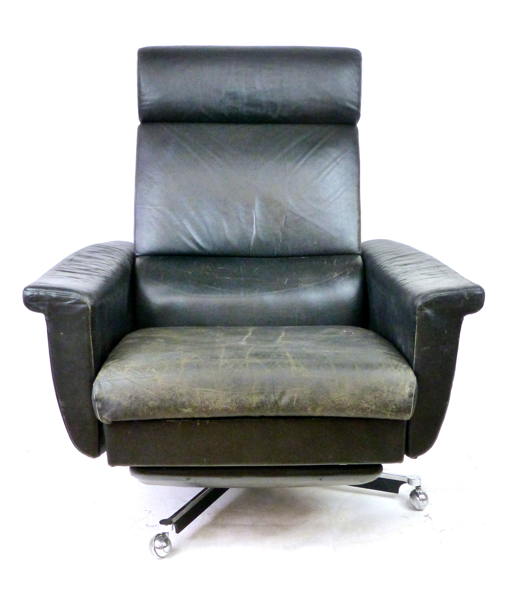 A 1970's black leather highback reclining armchair on a chromed five-star swivel base CONDITION