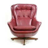 A 1970's maroon vinyl wingback armchair on a teak four-star rocking base CONDITION REPORT: Some