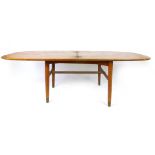 A 1960's teak folding coffee table of cushioned form on circular tapering legs ending with brass