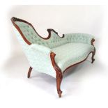 A Victorian walnut framed chaise longue, carved and scrolling top rail above a buttoned back,