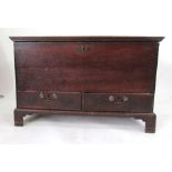 An 18th Century oak dowry chest, hinged cover above a base with two drawers with swing handles and