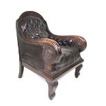 A Victorian oak framed and leather upholstered gentleman's chair with buttoned, floral carved