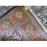 A Turkish hereke wool carpet, central ground with stylized flower head decoration, inside a multi